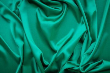 Elegant soft abstract green background. Delicate silk waved fabric with copy space for design projects