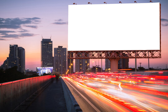 Blank billboard on light trails, street, city and urban in the twilight - can advertisement for display or montage product or business.