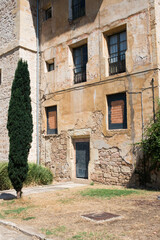 Fototapeta na wymiar Ancient stone facade of a house and garden in front of it. Oña, Burgos, Merindades, Spain, Europe