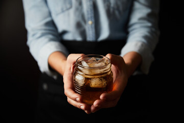 female barista hands offering a cup of iced tea drink