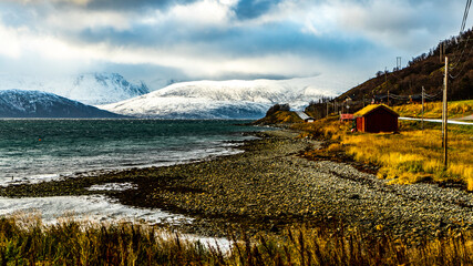 altes Haus am Ufer des Fjord an einem stürmischen Tag in Troms, in der Nähe von Tromsö,...