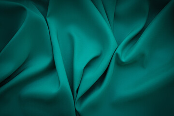 Elegant soft abstract dark green background. Delicate silk waved fabric with copy space for design...