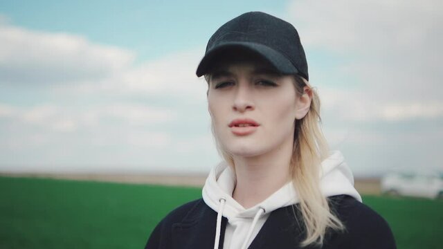 young girl looks indignantly at the camera, in the background a green field. Portrait of an offended girl.