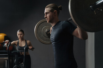 Caucasian young sporty couple working out together at gym. Group functional circuit training with crossfit equipment. Man and woman training at sport club