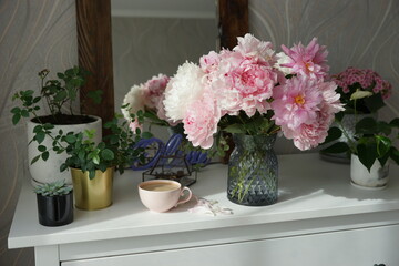 Bouquet of pink peonies on the dresser in the bedroom