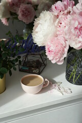 Bouquet of pink peonies on the dresser in the bedroom