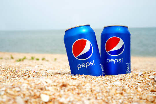 STRELKOVOYE, UKRAINE - 23 June 2021: Illustrative editorial of two cold Pepsi cans on the beach.