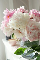 Bouquet of pink peonies on the dresser in the bedroom