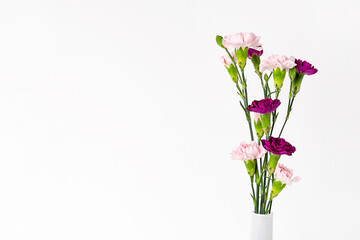 Bouquet of pink flowers in white vase at shelf. Modern minimalist interior.