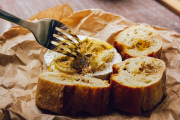 DIY baked cheese camembert instruction step by step. step 5 Camembert tasting. melted cheese stretches. cheese with white mold.moldy cheese