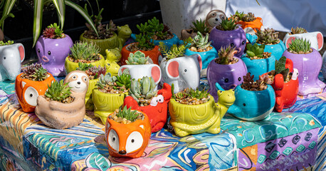 Fototapeta na wymiar A display of small animal ceramic planters at a stall in a farmers market in Salem Oregon