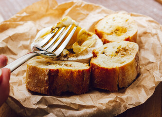DIY baked cheese camembert instruction step by step. step 5 Camembert tasting. melted cheese stretches. cheese with white mold.moldy cheese