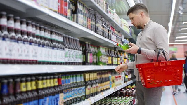 Man customer buying bottled beer in the supermarket