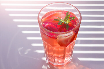 Still life with glass of cooling strawberry Sangria with sparkling wine, strawberry, ice cubes. Refreshing summer alcoholic cocktail drink , lemonade or ice tea. Copy space for text