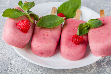 Homemade cooking vegan raspberries and coconut milk popsicles. Natural fruit and berry pink ice...
