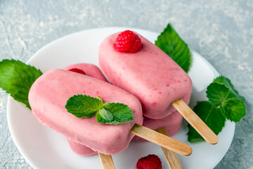 Homemade cooking vegan raspberries and coconut milk popsicles. Natural fruit and berry pink ice...