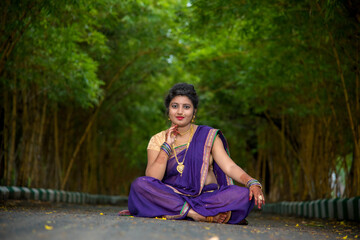 Fototapeta premium Indian Traditional Beautiful young girl in saree posing outdoors