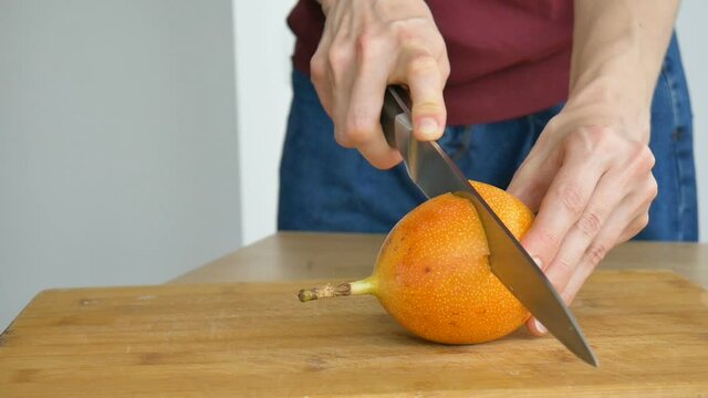Fresh organic ripe granadilla or yellow passion fruit cut in half on a wooden board. Exotic fruits, healthy eating concept