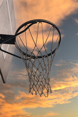 detail of a basketball hoop in the street at sunset on a sunny day with clouds