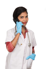 Female doctor with stethoscope talking on mobile phone on white background