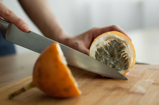 Fresh organic ripe granadilla or yellow passion fruit cut in half on a wooden board. Exotic fruits, healthy eating concept