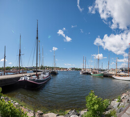 Fototapeta na wymiar Old sailing cargo ships at a jetty in the bay Ladugårdsviken in Stockholm