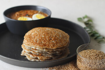 Kodo millet pancakes served with egg roast. Pancake is made with a fermented batter of kodo millet, flattened rice, coconut. Egg roast is Boiled egg in a spicy gravy of onions, tomatoes, spices