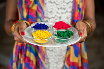 Young girl holding powder colors in plate on the festival of colors called Holi, a popular Hindu festival celebrated across India