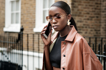 Young black woman using her mobile outdoors.