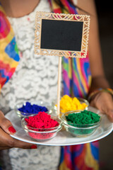 Young girl holding small board and powdered color on the occasion of Holi festival.