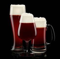 Set of fresh stout beer glasses with bubble froth isolated on black background.