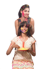 Happy young girls having fun with colorful powder at Holi festival of colors