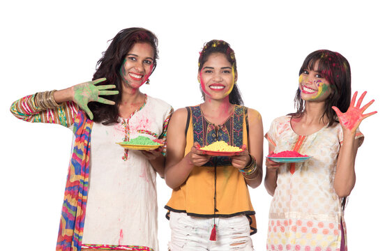 Happy young girls having fun with colorful powder at Holi festival of colors