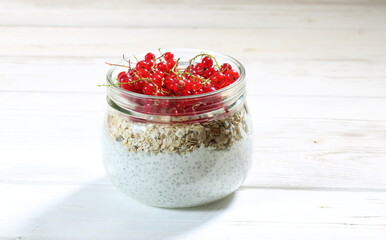 Cottage cheese dessert with chia, strawberries and currants on a white background