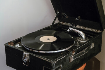 Vintage classic record player in the form of a black suitcase. Vinyl record.