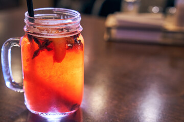Christmas drink red non-alcoholic mulled wine with a straw on the background of the cafe interior, order for one