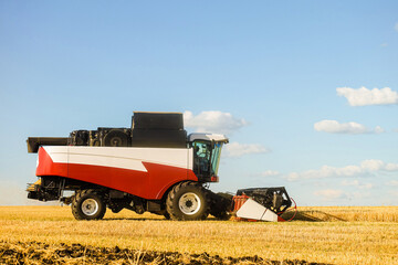 Combine harvester with cutter platform at work. Side view.
