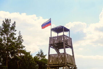 Wooden watch post tower with the flag of Russia