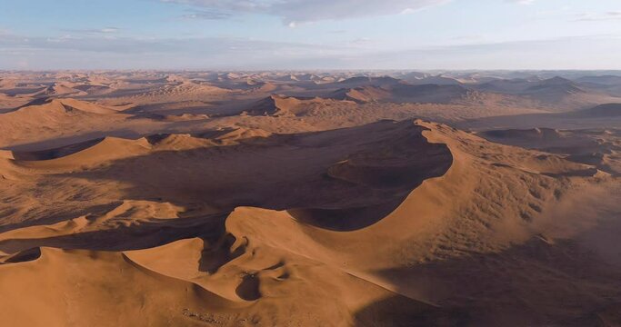 Drought. Climate change.Climate emergency.Global warming.Spectacular epic aerial panning view of endless sand dunes of the Namib desert 