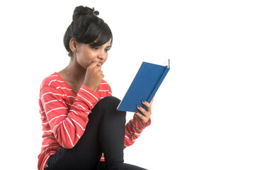 Pretty young girl holding book and posing on white background