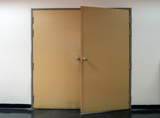 The large metal door was left ajar after someone entered the filing room.