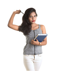 Pretty young girl holding book and posing on white background