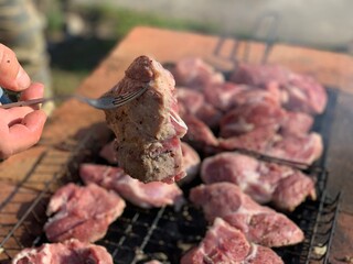 Raw marinated meat in spices is grilled. Cooking pork. BBQ meat.