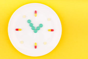 a white plate in the form of a dial on which there are pills and tablets