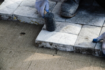 Construction of pavement near the house. Bricklayer places concrete paving stone blocks for building up a Sidewalk pavement