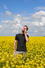 a guy with allergies to plants and pollen rubs his eyes and nose