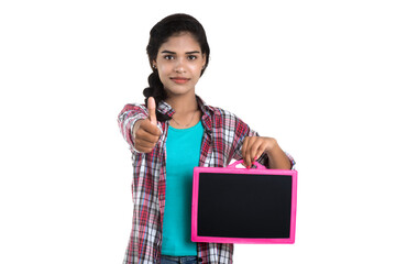 Beautiful young girl holding or posing with a chalkboard slate on a white background