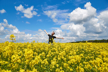 Happy guy enjoying life without pollen allergy in a rapeseed field