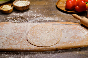 roll the dough into a thin tortilla on a cutting board. 