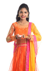 Beautiful Indian young girl holding pooja thali or performing worship on a white background